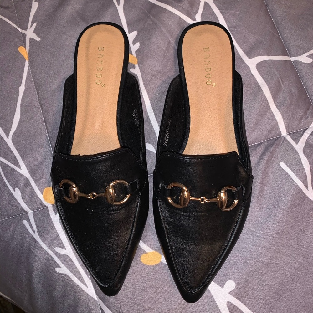Black mules, with buckle detail.